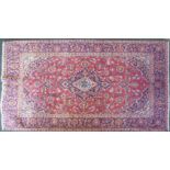 A Kashan medallion Rug with flower heads on a red field and bordered. 7' 1" (216cms) x 4 '7" (