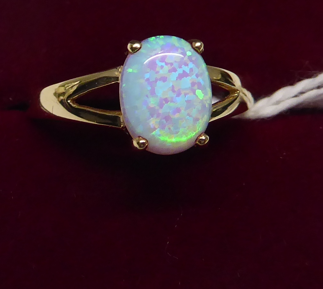 A 9ct. gold Dress Ring with a single opal in an open work setting.