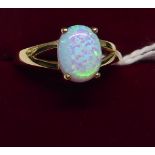 A 9ct. gold Dress Ring with a single opal in an open work setting.