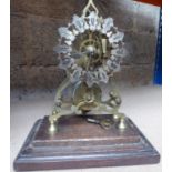 A brass Skeleton Clock with single fusee movement on an oak plinth and in a glazed case, 12" (31cms)