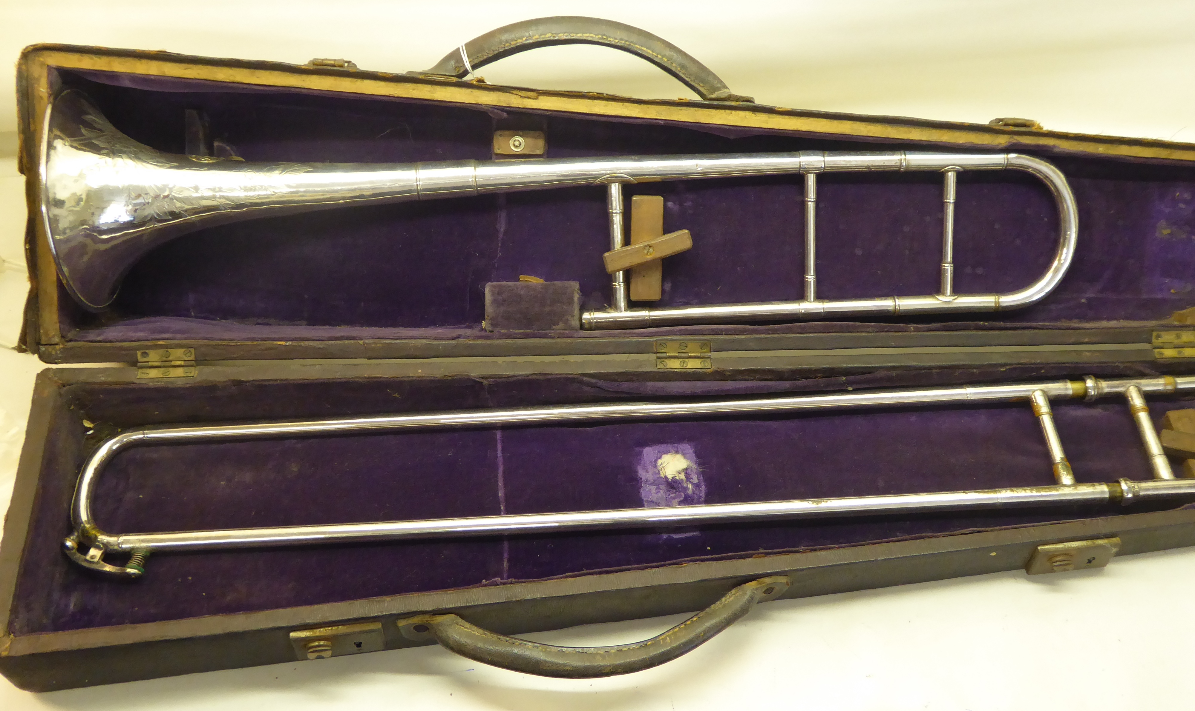 A silver plated Trombone with engraved decoration, cased.