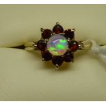A 9ct. gold Cluster Ring with a centre opal surrounded by garnets.