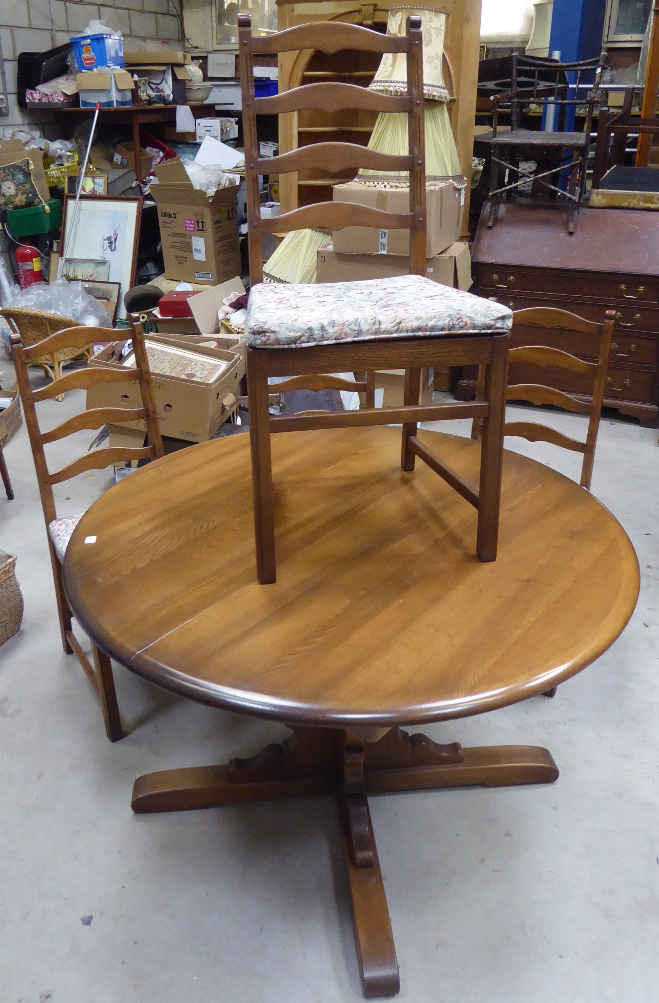 A Ercol Golden Dawn elm circular Dining Table with extension leaf, and a set of four ladder back