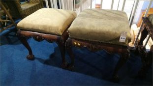 A pair of mahogany claw and ball stools