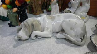 A Lladro dog and two figures