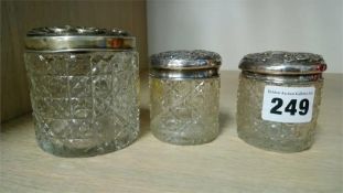 Three silver top cut glass containers