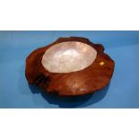 A carved wooden bowl with mother of pearl centre.