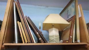 Shelf of pictures and lamps.