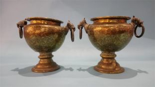 A pair of ornate Middle Eastern brass vases, with ring handles.