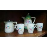 Clarice Cliff coffee pot, three cups and a jug