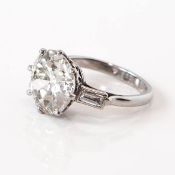 A platinum 6.74ct old cut solitaire diamond ring, with two baguette cut diamonds to each shoulder,