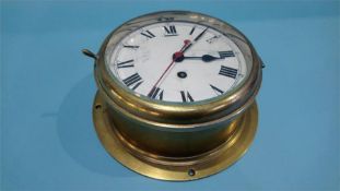 A brass ships clock with enamelled dial