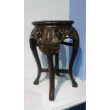 An Oriental carved hardwood table with inset marble to the top and carved legs, 30cm diameter (max)