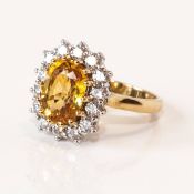 An 18ct gold yellow (sapphire) and diamond ring, the yellow stone 4.00ct; with 14 diamonds, colour