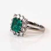 An 18ct white gold emerald and diamond ring, the emerald approx. 3.30ct with 12 brilliant cut