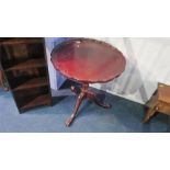 A reproduction mahogany tilt top table