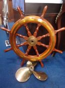 A reproduction Ship's wheel and a propeller