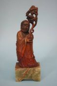 A carved horn figure of a Chinese gentleman on an onyx base. 23cm high