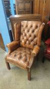 A brown Chesterfield armchair