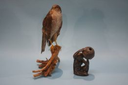 A taxidermy of a bird of prey and a metal ware model of a nude holding aloft the world (2)