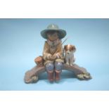 A Lladro group of a fisher boy on a bridge with his dog at his side, numbered 2237
