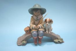 A Lladro group of a fisher boy on a bridge with his dog at his side, numbered 2237