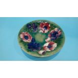 A Moorcroft shallow bowl on a green ground, decorated with flowers, impressed mark and signed,