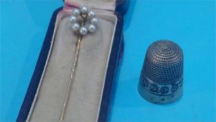 A seed pearl tie pin and a silver thimble