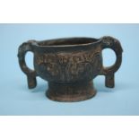 A Chinese antique bronze vessel, with two looped handles and incised decoration. 10cm diameter,