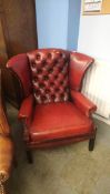 A red Chesterfield wing armchair