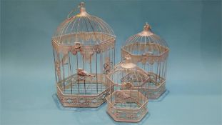 A set of three graduating bird cages