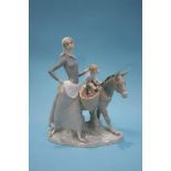 A Lladro group of a mother with her child and donkey collecting water, 34cm wide