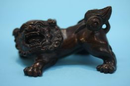 A carved hardwood netsuke in the form of a dog of Fo