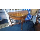 A walnut demi lune fold over card table, with claw and ball feet, 83cm wide