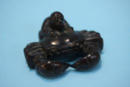 A carved hardwood netsuke in the form of a crab and a monkey