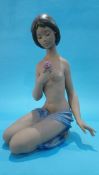 A large Lladro group of a nude girl kneeling holding a pink rose, 46cm high