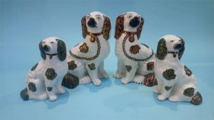 Two pairs of Staffordshire Spaniels, 23cm high and 17cm high