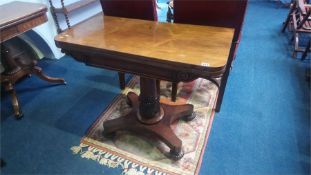 A William IV rosewood fold over card table, with turned and acanthus carved central column,
