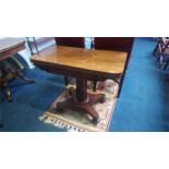 A William IV rosewood fold over card table, with turned and acanthus carved central column,