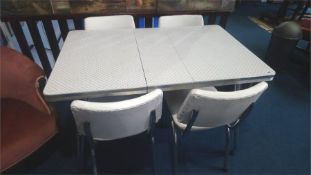 A Formica and chrome kitchen table with four chairs
