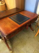 A reproduction Wade mahogany writing desk, with tooled gilt leather top and three frieze drawers,