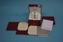 A Ladies 18kt gold Cartier watch, with diamond bezel, complete with original boxes, paperwork,