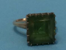 An unmarked gold coloured ring set with green stone, size M , 6.3grams