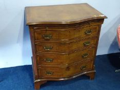 A reproduction walnut serpentine front chest of drawers, with brushing slide, 71cm wide