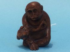 A carved netsuke in the form of a monkey and a frog