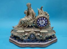 A gilt metal clock with enamelled dial and stand