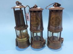 Two Eccles miners lamps and a modern lamp