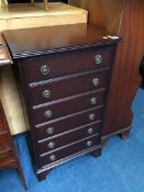 A reproduction mahogany narrow chest of six drawers