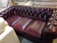 An oxblood three seater leather Chesterfield sofa