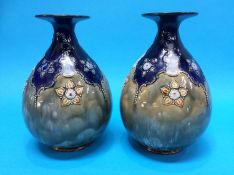A pair of Royal Doulton stoneware globular vases, decorated with stylised flowers, impressed